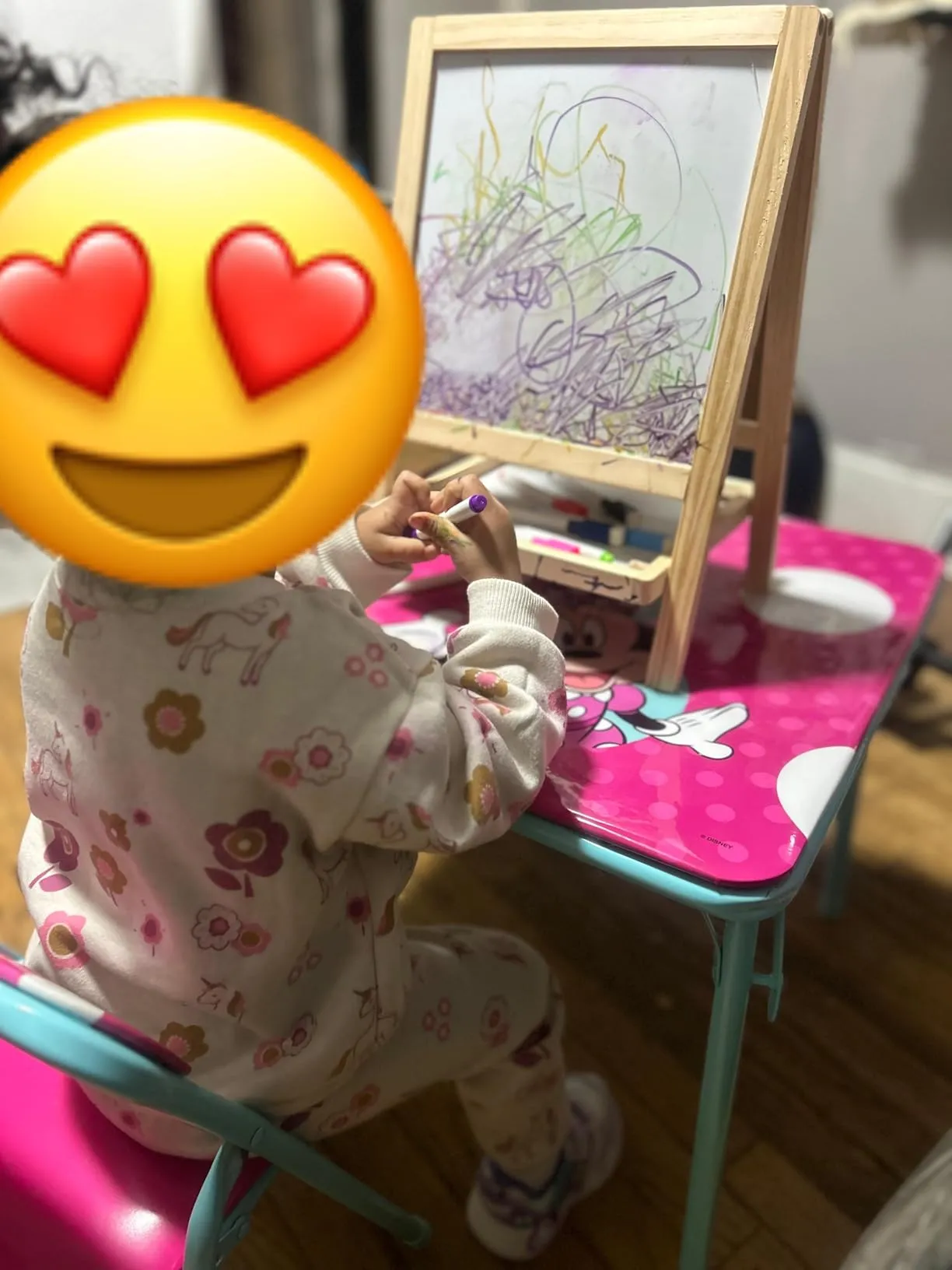 Kid drawing enthusiastically with colorful markers