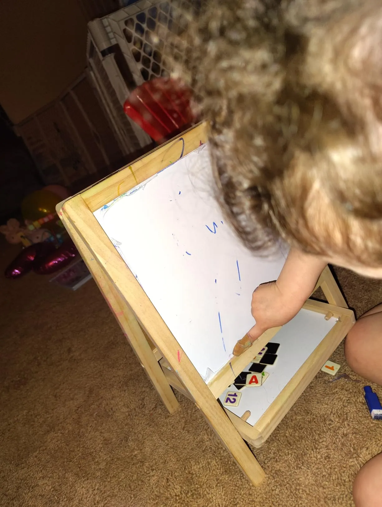 Young child drawing on whiteboard close up