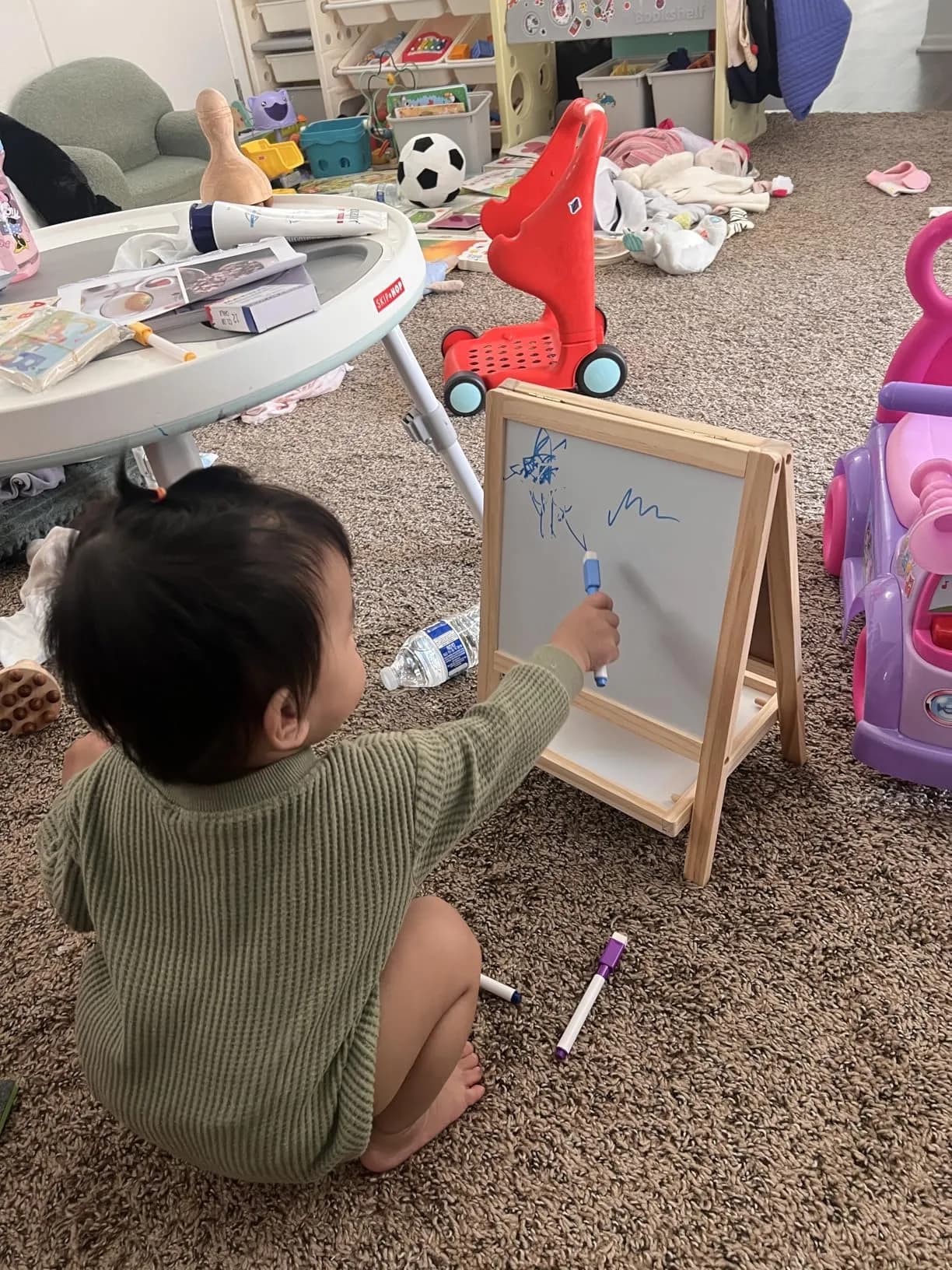 Toddler in green sweater creating art